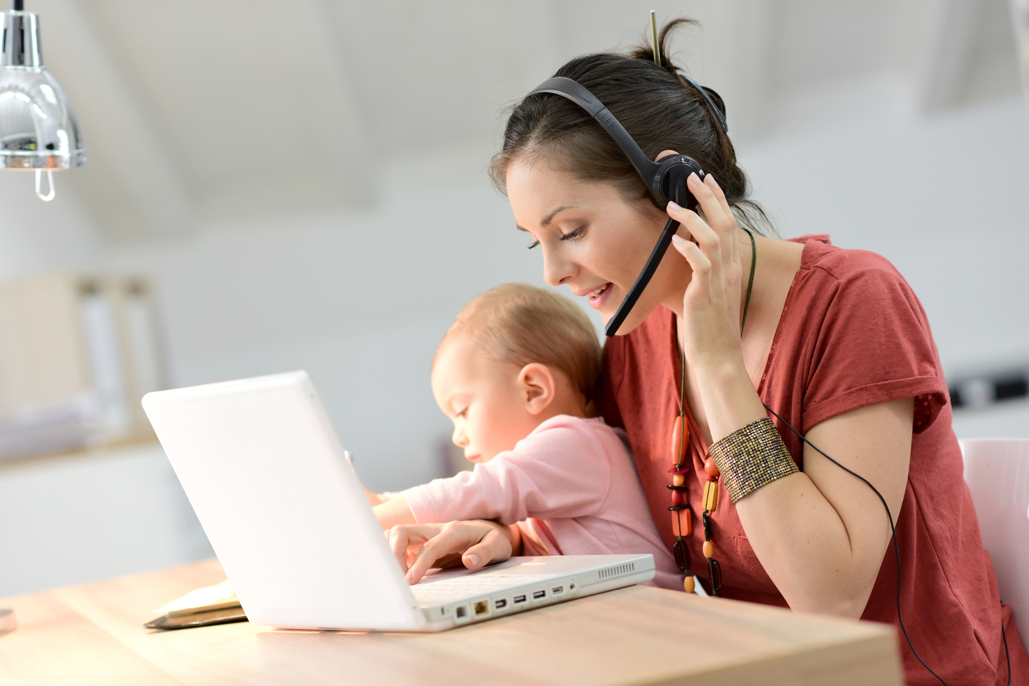 Busy businesswoman working with baby on lap